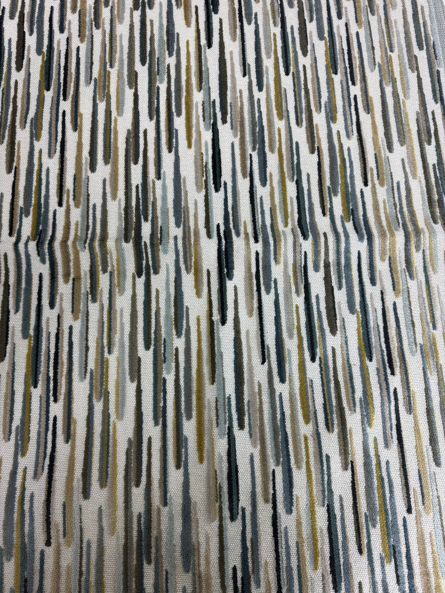 Textured fabric with abstract pattern in brown, black, blue, and beige tones.