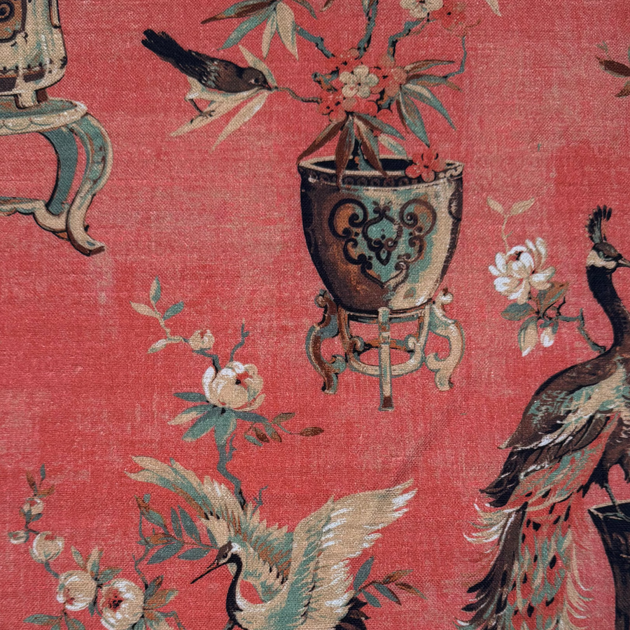 Fabric with peacock and floral design on a red background