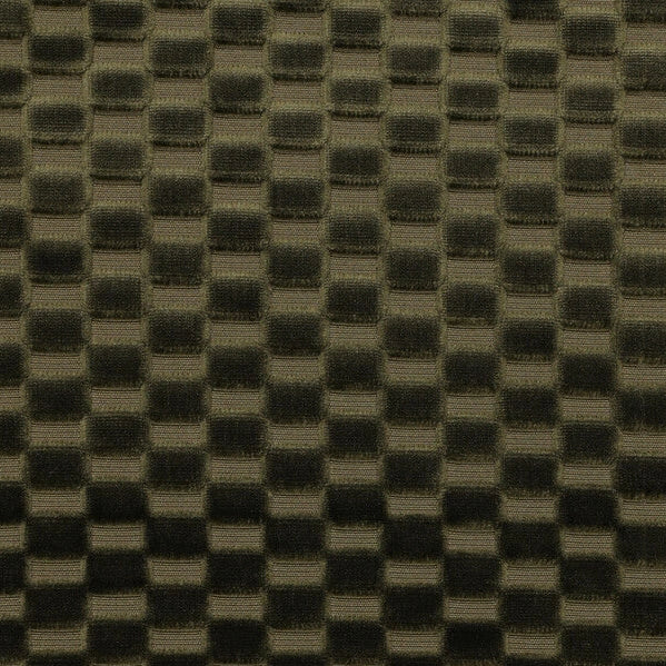 Dark olive green textured fabric with a repeating raised checkerboard pattern, shown with a wooden ruler at the bottom for scale.