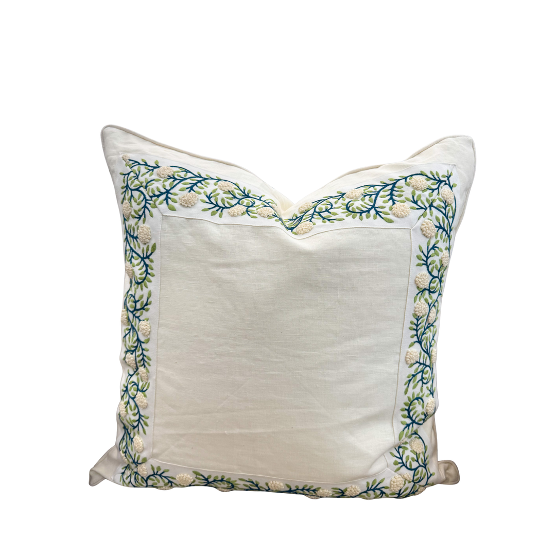 Decorative pillow with floral embroidery on a white background