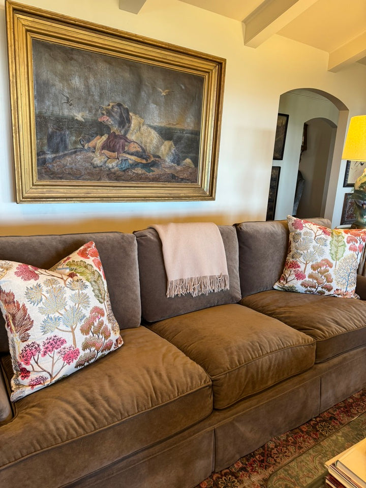 floral embroidered pillow on a velvet sofa