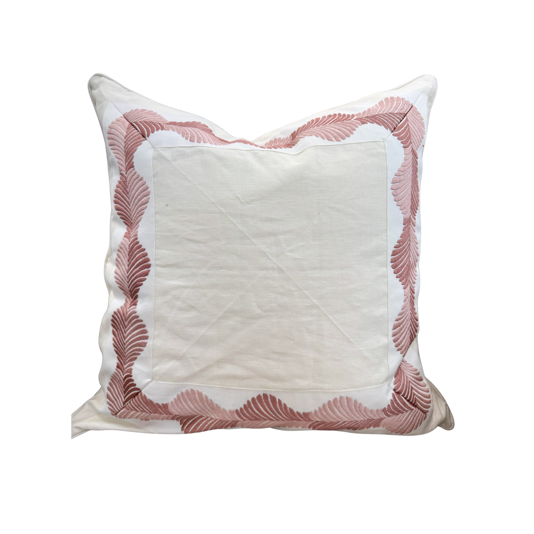 Decorative pillow with pink feather pattern on a white background