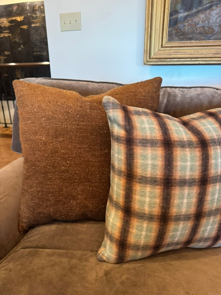 brown and check pillows on a velvet sofa