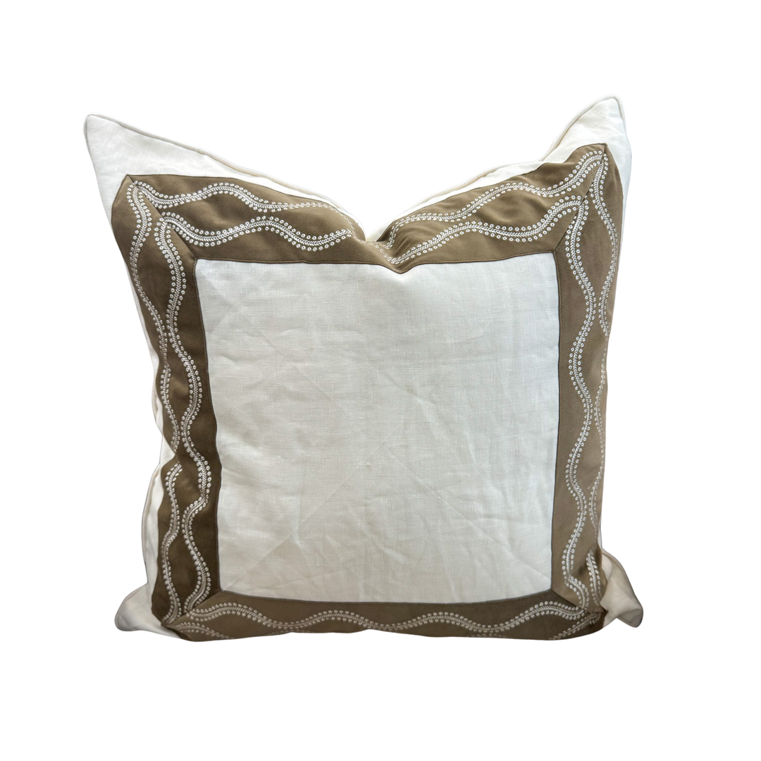 Decorative pillow with brown and white embroidery on a white background
