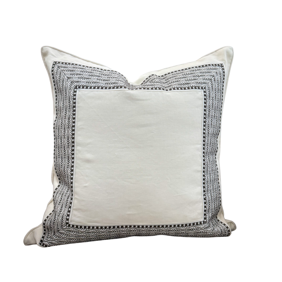 Decorative pillow with brown embroidered border on a white background