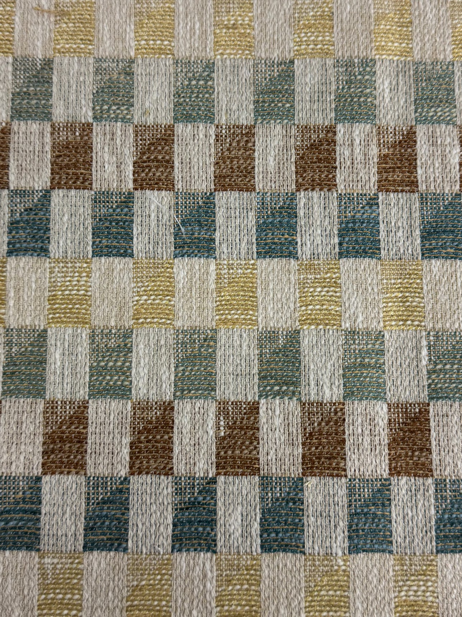 Checkered fabric swatch with brown, green, and beige squares on a white background