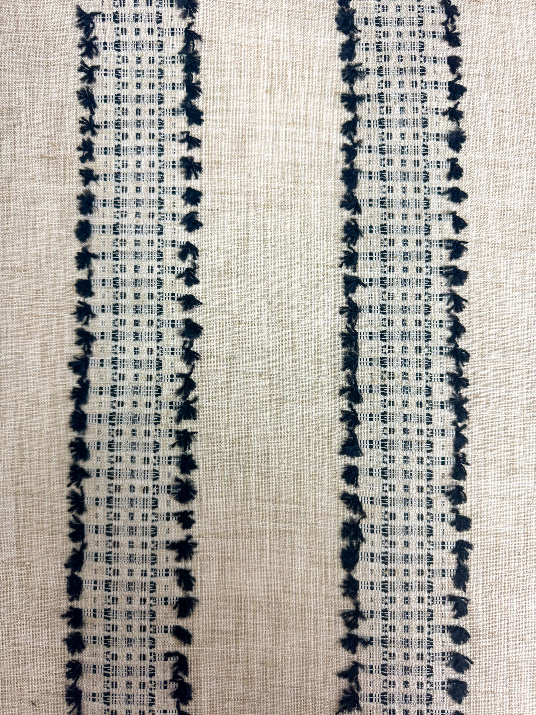 tan and black embroidered striped fabric