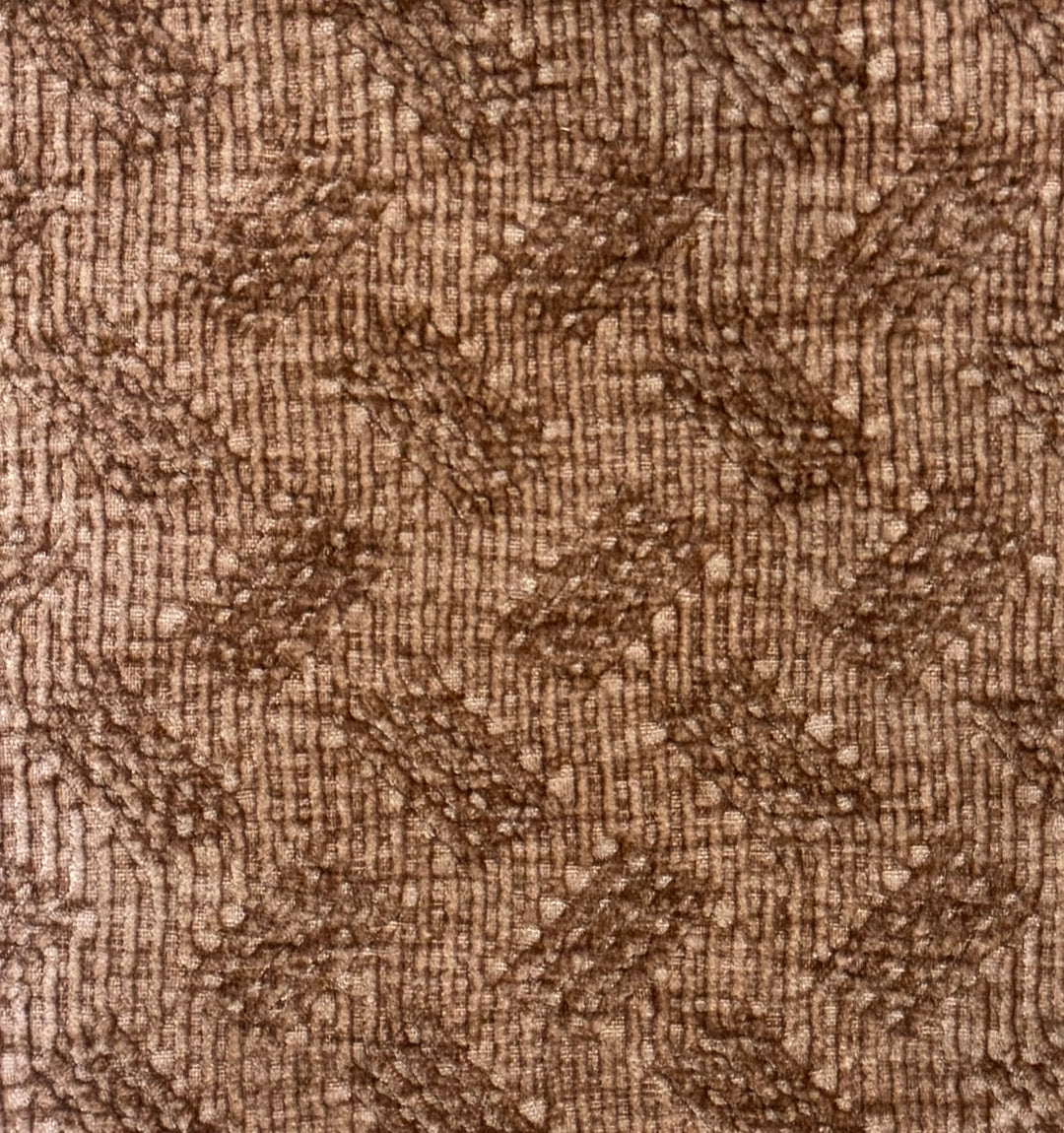 A close-up of a brown textured fabric with a woven geometric pattern.