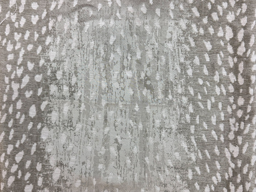 A close-up of a textured fabric with a distressed pattern, featuring a central light gray and white vertical streak pattern surrounded by a gray and white spotted border.