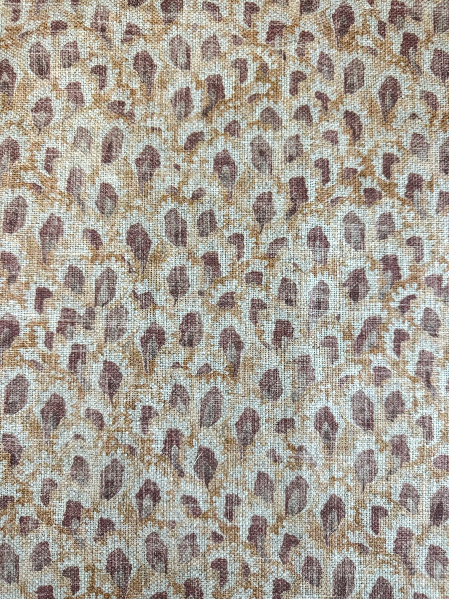 Textured fabric with a subtle pattern of brown and beige shapes on a neutral background