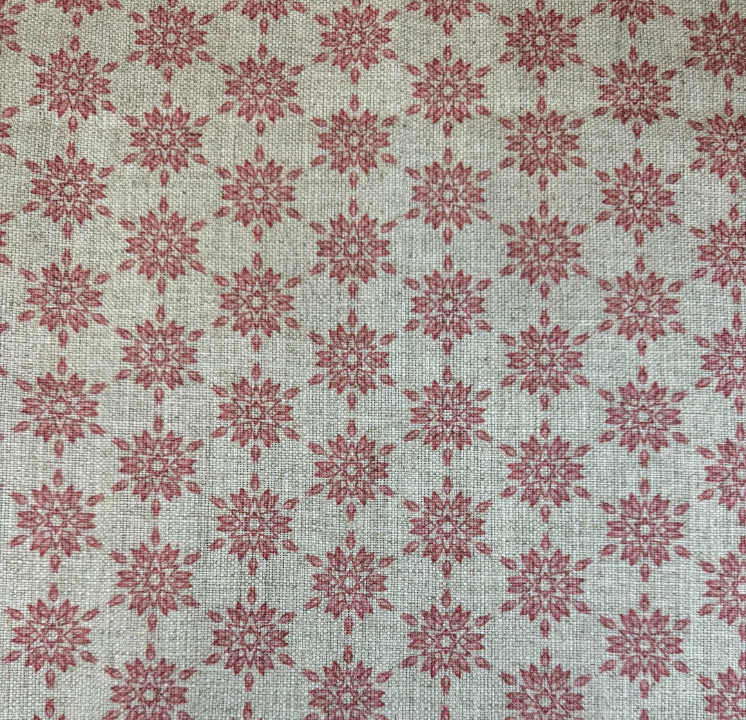 Patterned fabric with red geometric design on a taupe background