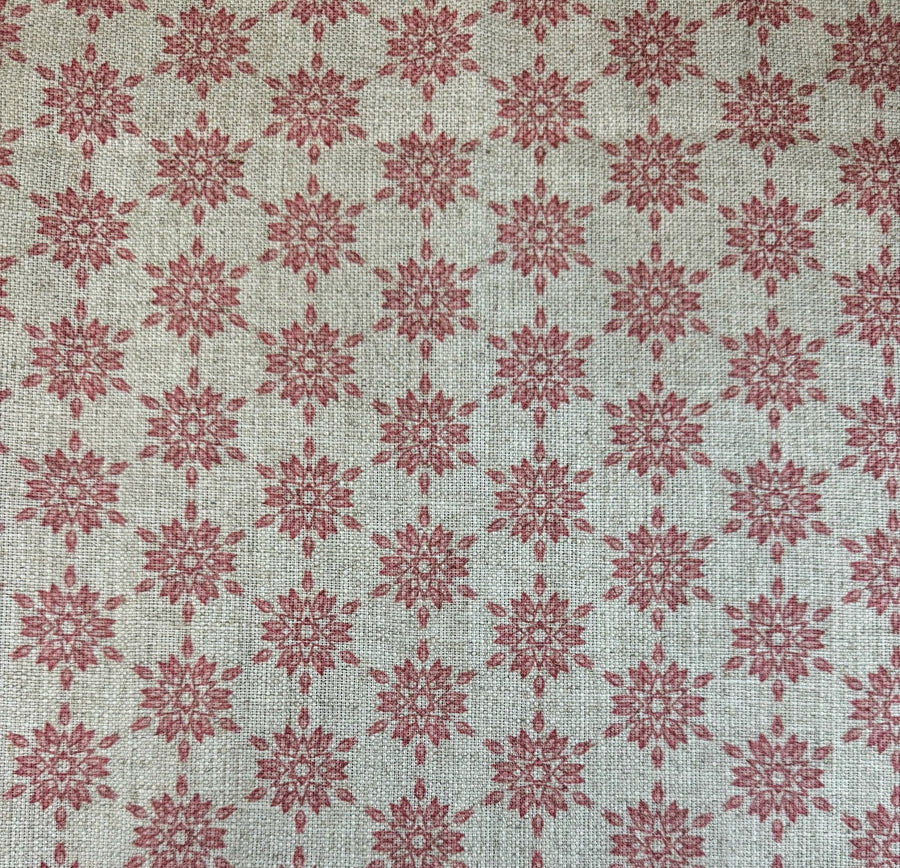Patterned fabric with red geometric design on a taupe background
