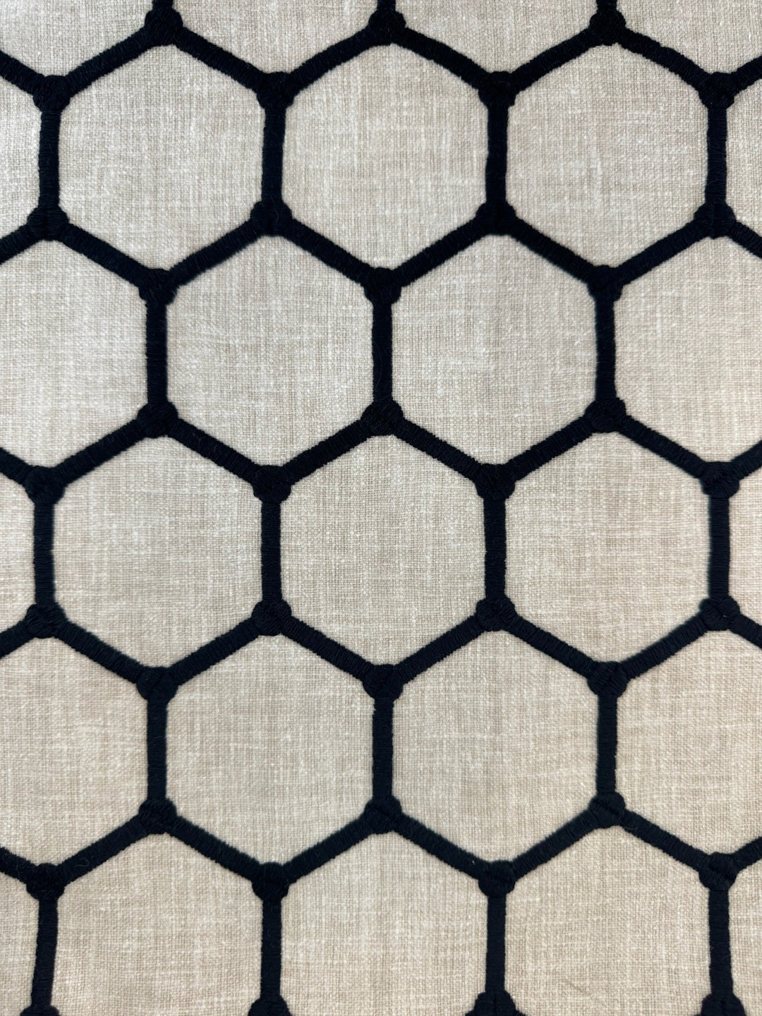 Hexagonal pattern fabric texture with black lines on a beige background