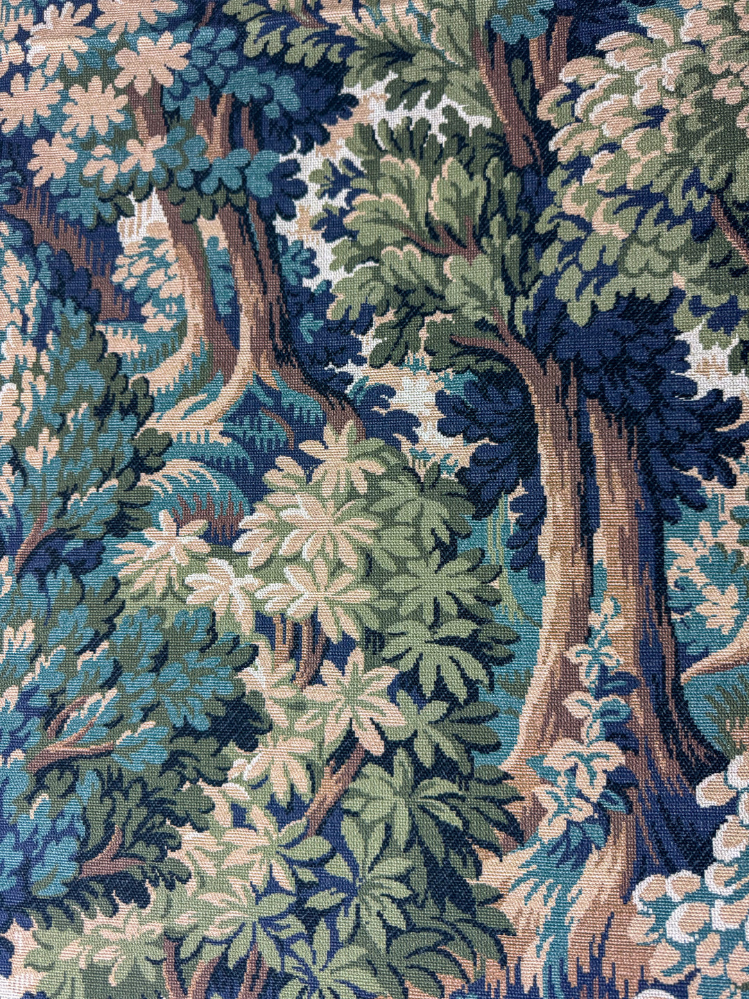 Patterned fabric with a forest design featuring trees and foliage.