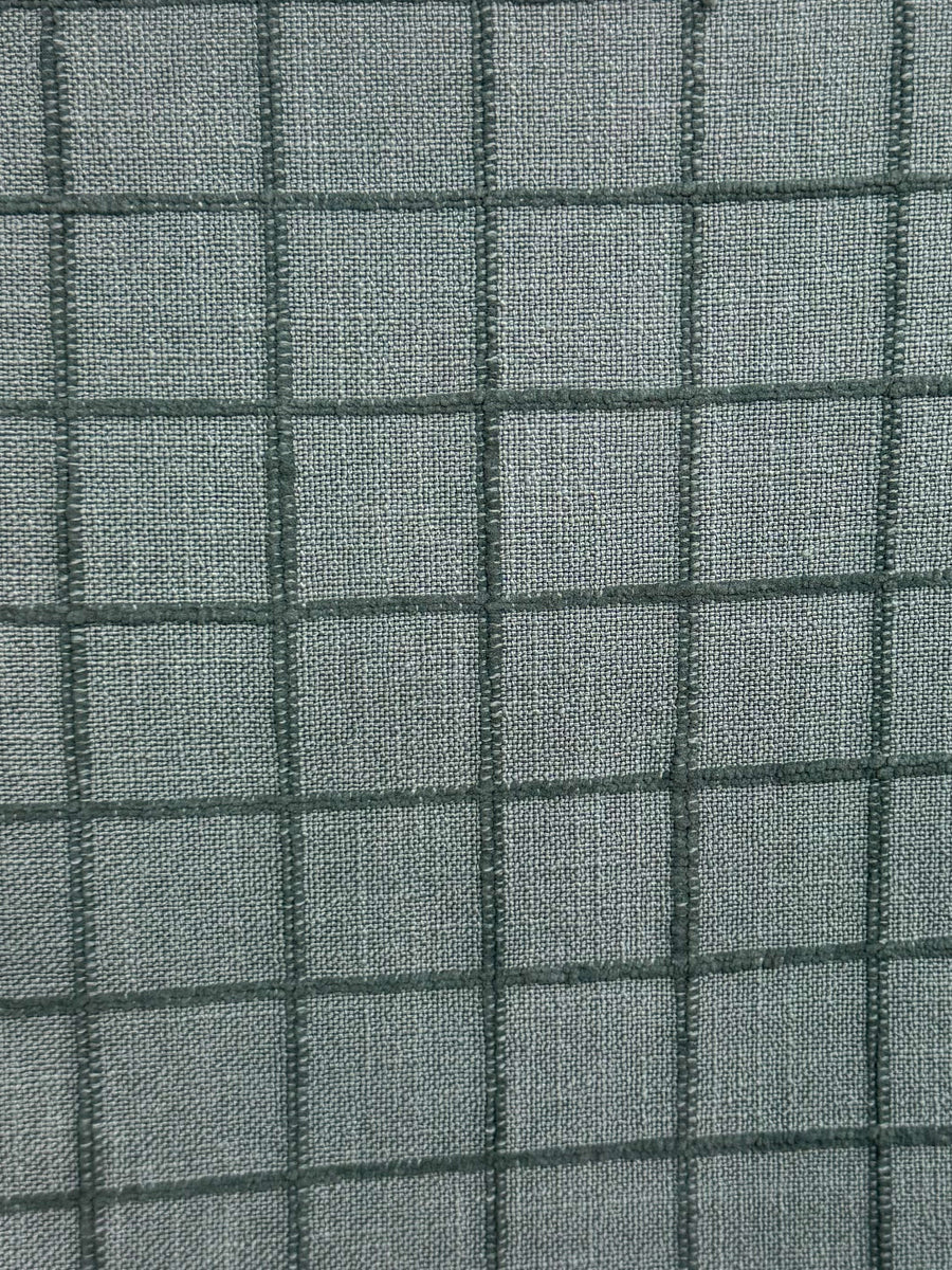 Close-up of a textured fabric with a grid pattern in blue tones.
