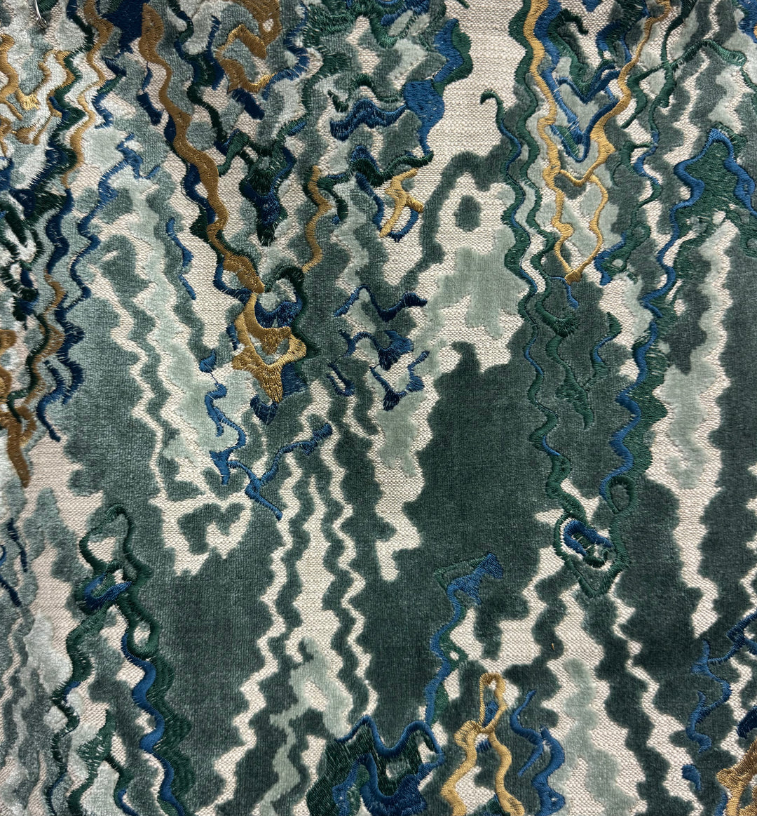 Close-up of a textured fabric with wavy pattern in green, blue, and gold.