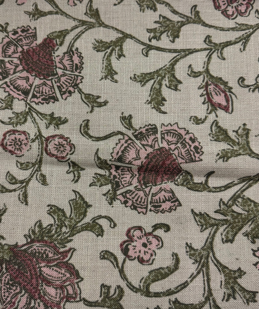 Close-up of floral fabric pattern with pink and green colors on a neutral background