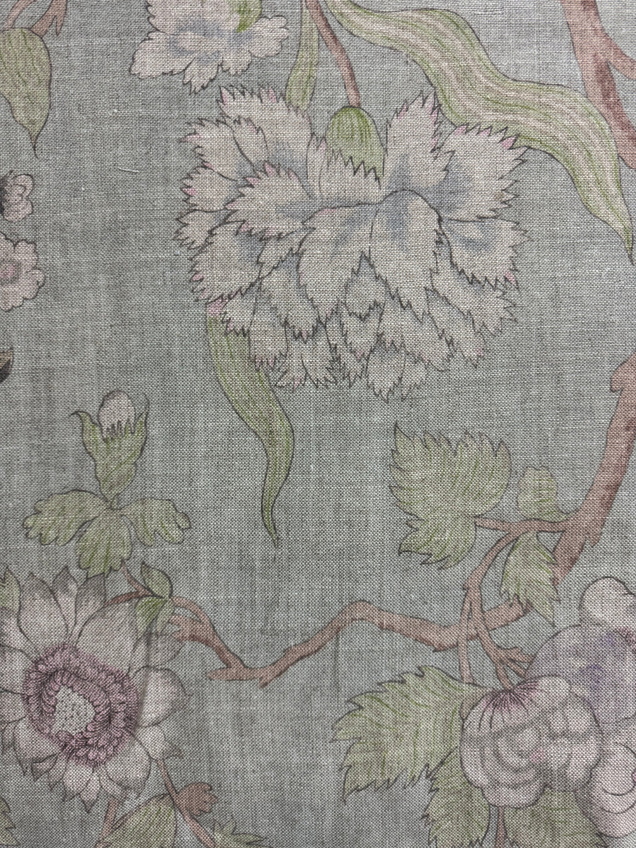 Floral patterned fabric with green leaves and purple flowers on a gray background