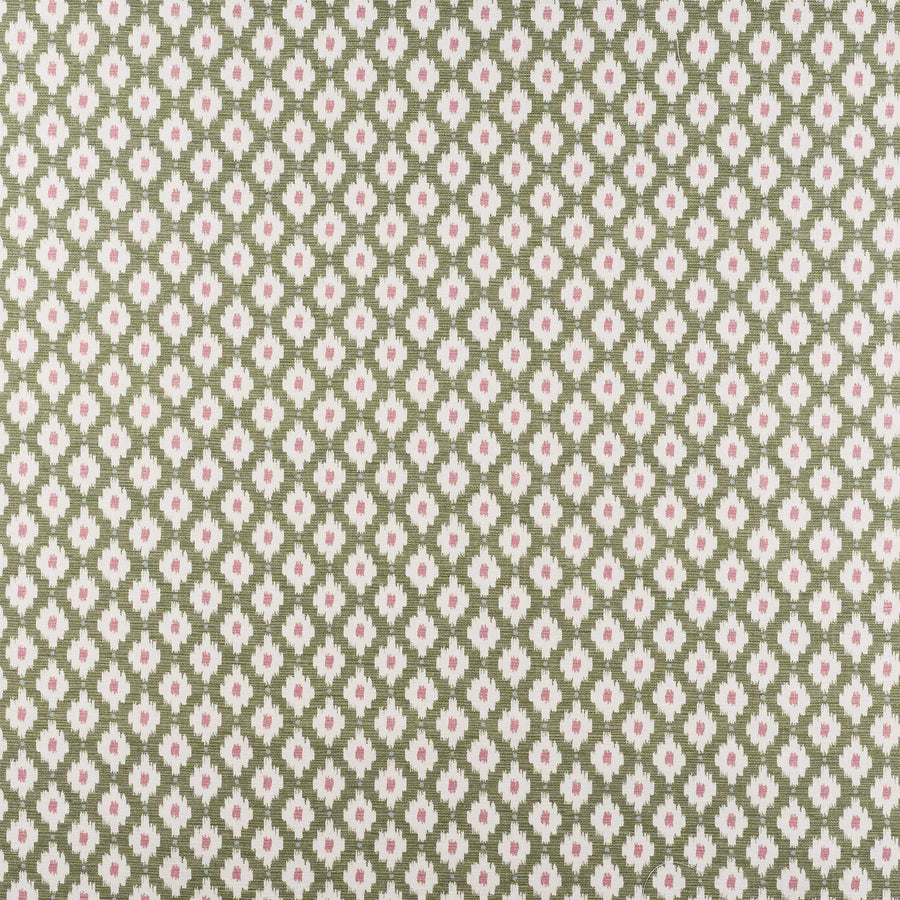 A close-up of a repeating fabric or wallpaper pattern featuring small pink flowers and green leaves arranged in a diamond ikat design on a muted sage green background.