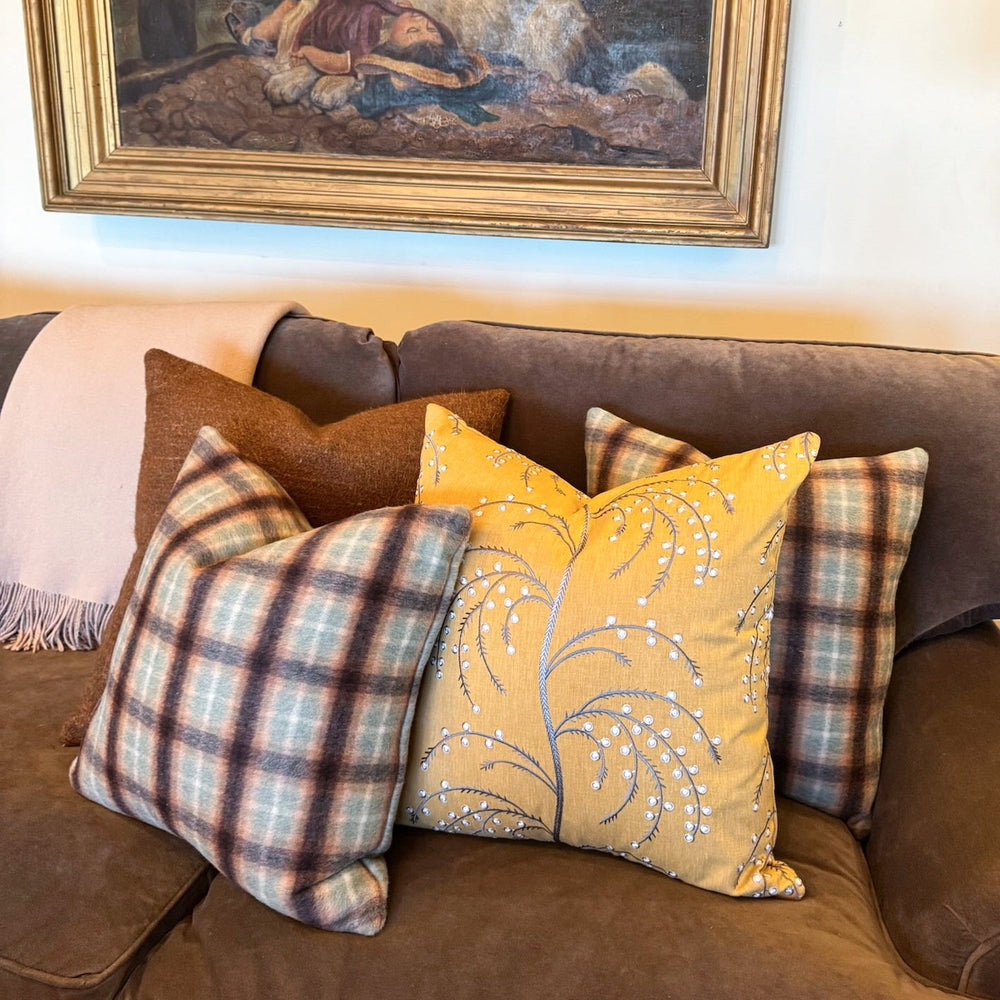 Brown sofa with decorative pillows and a framed painting above it