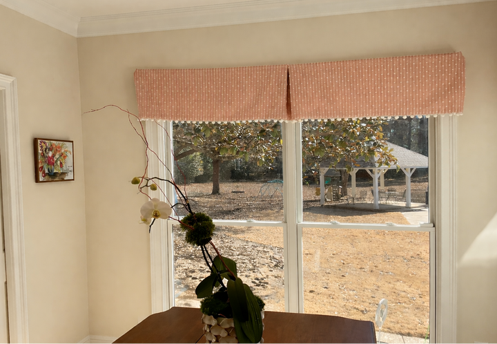 Living room with a window view of a gazebo, a plant on a table, and a painting on the wall.