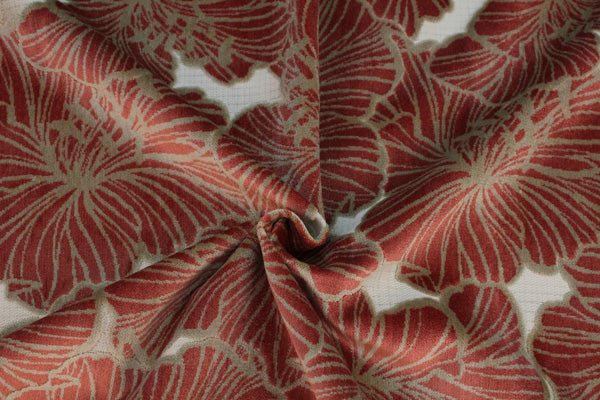 A fabric with a floral pattern in red and beige colors, appears to be velvet material.